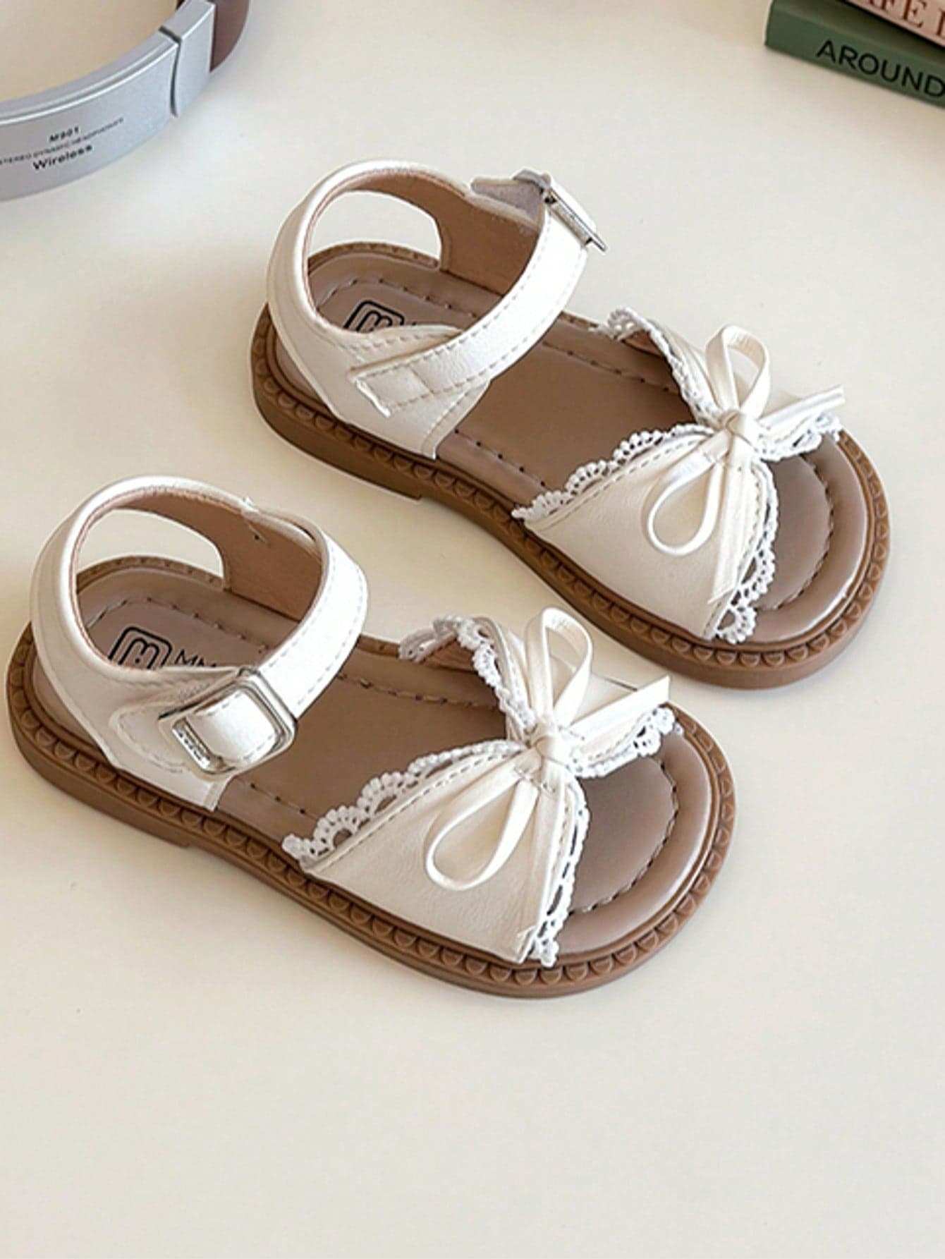 This Popular White Children's Sandals Feature A White Strap And Metal Buckle Upper, With A White Bow And Lace Decoration On The Toe. The Sweet And Fresh Style Belongs To The Summer Fashion , Suitable For Children's Daily Wear And Vacation Occasions, Fitting For Ages 3-12.