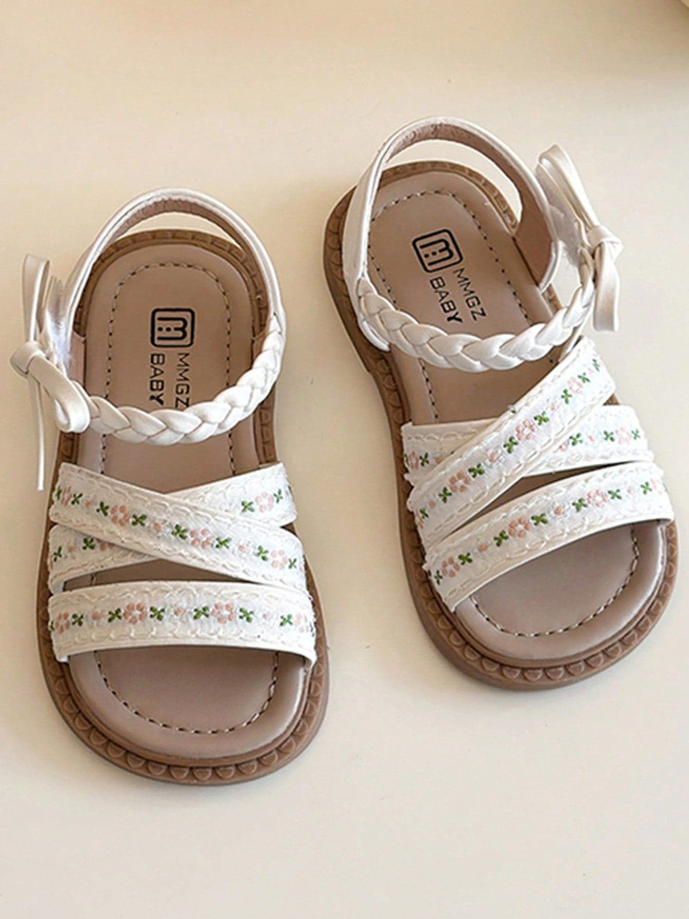 This Popular White Children's Sandals For Summer Feature A Woven Criss-Cross Strap Design, Decorated With Ditsy Floral Embroidery, And A Bowknot Accent At The Ankle, Paired With A Brown Sole. With A Sweet And Fresh Style, This Is A Fashionable Summer Option Suitable For Children's Daily Wear And Vacations, Fitting Kids Aged 3-12.