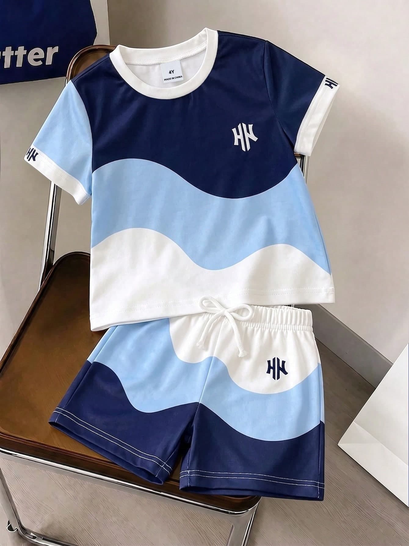 SHEIN Streecool Kids Young Boy Classic Geometric Pattern Fresh Blue & White Contrast Wave Print Multi-Color Knitted Comfortable Soft Crew Neck Short Sleeve T-Shirt, Paired With Matching Print Elastic Waist White Bow Decor Shorts, Boys Short Sleeve Shorts Set, Boys 2-Piece Set, Suitable For Summer, Simple Suitable For Sports, Vacation, Outing, Suitable For 4-7Y
